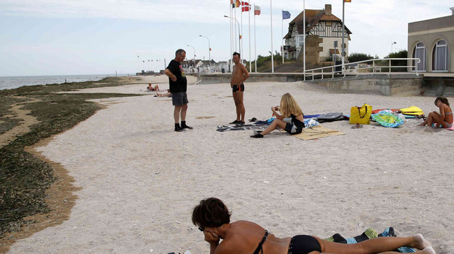 Una turista toma el sol en la antigua zona de desembarco de la playa Juno, donde las tropas canadienses desembarcaron el Día D