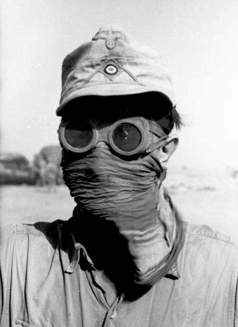 Soldado del Afrika Korps usando gafas y cubriéndose la cara para protegerse contra las numerosas tormentas de arena