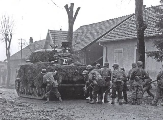 Un tanque Sherman de la 5ª División Blindada francesa, con apoyo de infantería en las afueras de Belfort. 20 de noviembre de 1944