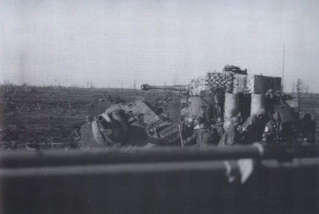 Un cañón de asalto soviético SU-122 puesto fuera de combate. Junto a él un Tiger del Kampfgruppe Strachwitz acompañado por granaderos