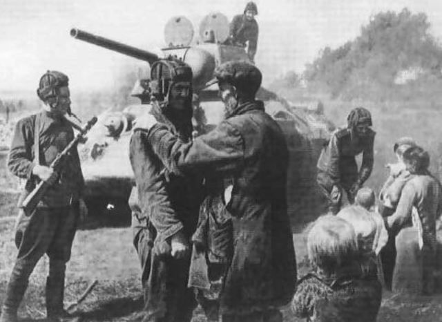 Imagen de propaganda del Ejército Rojo. Un T-34 76 y su tripulación junto a unos campesinos de una villa ucraniana liberada. Verano de 1943