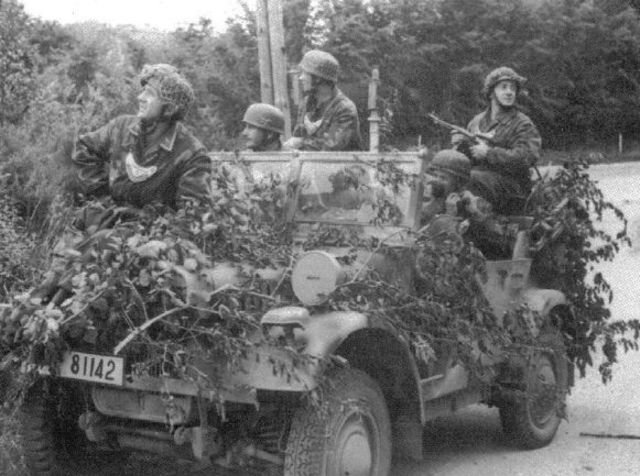 Soldados de la  Fallschirmjäger Feldgendarmerie  en un vehículo camuflado durante la batalla de Normandía